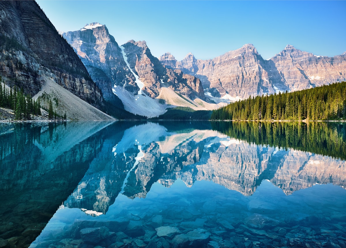 Turquoise waters of a pristine Canadian glacial lake reflecting surrounding mountain peaks