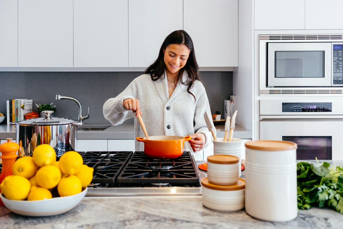 Compact organized kitchen with wooden shelves, storage containers, and tidy counters