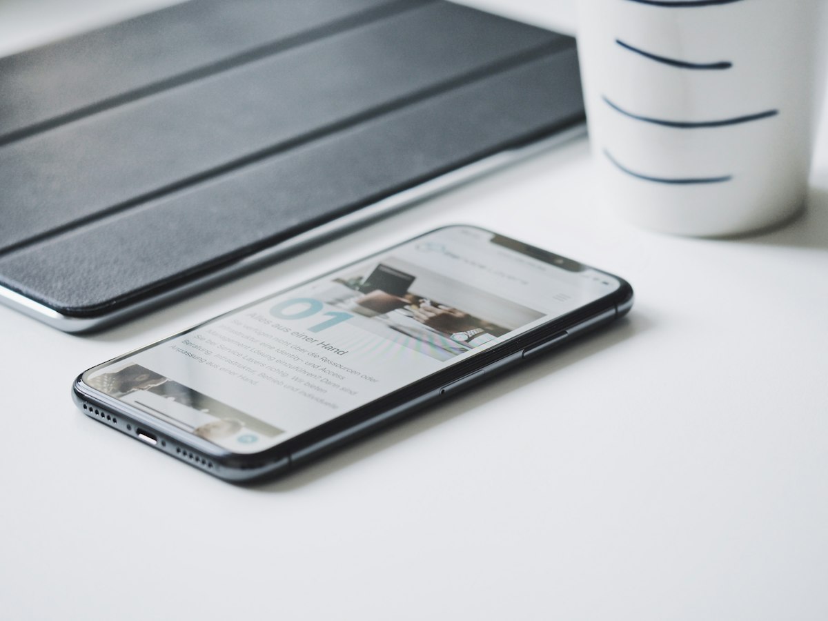 Modern smartphone lying on a clean wooden desk with thoughtful interface layout